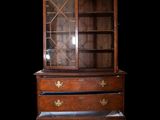 an antique wooden dresser with glass doors and drawers