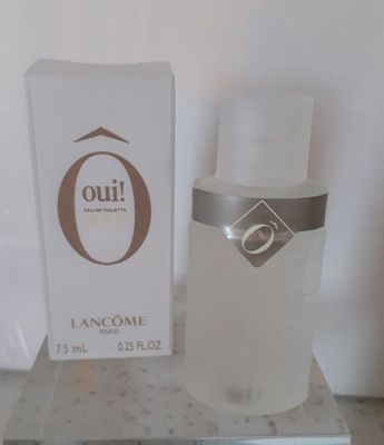 un flacon de parfum posé sur une table à côté d'une boîte
