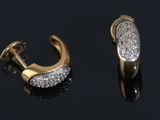 two pairs of gold and diamond earrings on a black surface