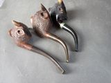 three pipe holders sitting on a table next to each other