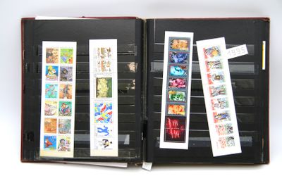 un livre ouvert, orné de timbres, posé sur une surface blanche