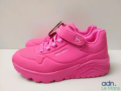 des chaussures roses pour enfants posées sur une surface blanche, sur fond blanc