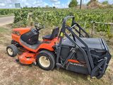 an orange lawn mower parked in the middle of a field