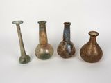 Plusieurs vases de différentes couleurs sont alignés sur une surface blanche