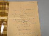 une note manuscrite sur un bout de papier posée à côté d'une boîte