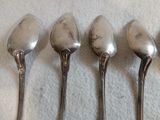 quatre cuillères sont alignées sur une table
