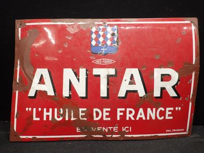 une vieille enseigne rouge et blanche sur laquelle est inscrit le mot « antar »