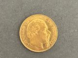 a close up of a gold coin on a gray surface