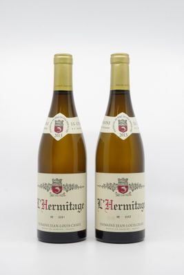 deux bouteilles de vin posées l'une à côté de l'autre sur une surface blanche