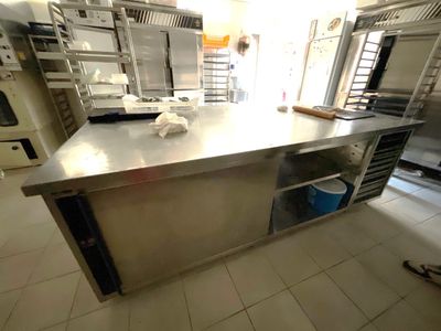 un grand îlot de cuisine en inox au milieu de la cuisine