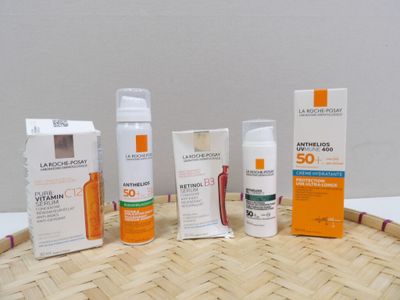 plusieurs crèmes solaires posées sur une natte en bambou