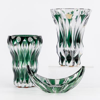 deux vases verts posés l'un à côté de l'autre sur une surface blanche