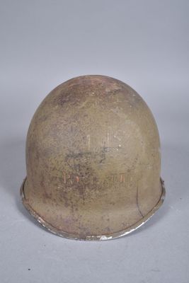 un vieux casque posé sur une table, sur une surface blanche