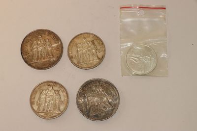 four coins are sitting on a table next to a plastic bag