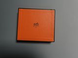 une boîte orange portant un logo, posée sur un mur gris