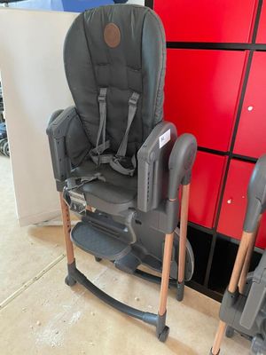 a baby chair that is sitting next to a red cabinet