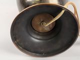 a large metal vase with a gold handle and a black lid