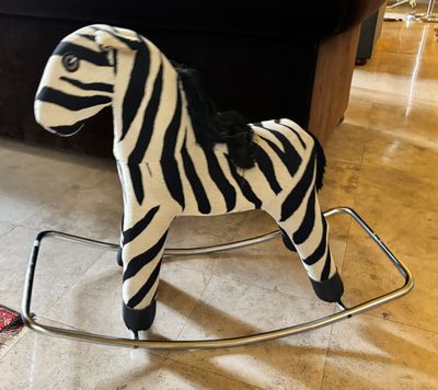 un jouet à bascule en forme de zèbre posé par terre dans le salon