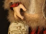 a doll that is holding a purse in her hand