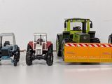 several toy tractors are lined up in a row on a white surface