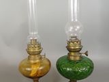 pair of green and gold glass oil lamps on a white background