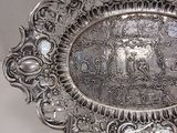 un plateau en argent orné d'une image, posé sur une table