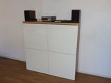 a white cabinet with speakers on top of it in a room