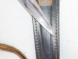 a knife that is laying on top of a piece of leather