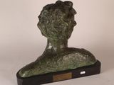 a bronze bust of a man on a wooden base