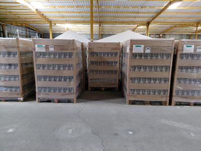 a bunch of boxes of water are stacked up in a warehouse