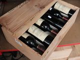 bottles of wine are in a wooden box on a table