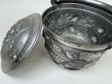 a silver pot with a lid sitting on a table