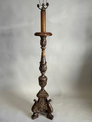 un lampadaire ancien en bois surmonté de deux lampes