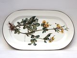 a white plate with yellow flowers and green leaves on it