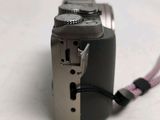 a silver camera with a pink cord attached to it