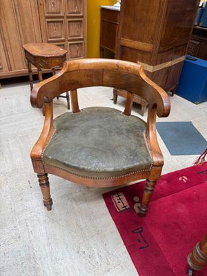 a wooden chair with a green seat in a room