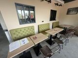 tables and chairs in a room with a window and a sign