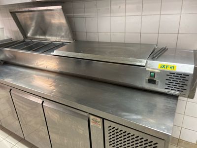 stainless steel counter top in a commercial kitchen with a large oven