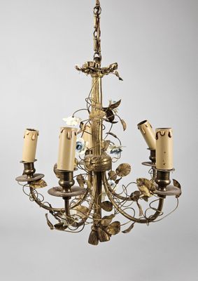 un lustre ancien en laiton, orné de cinq bougies et d'un oiseau