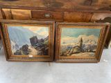 two paintings of a mountain scene are on display in front of a dresser
