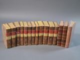 plusieurs vieux livres alignés les uns à côté des autres sur une surface grise