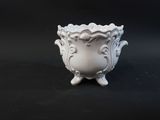 a small white vase sitting on a black surface