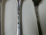 three spoons that are sitting next to each other on a table