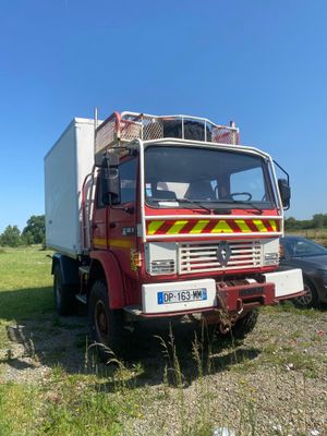 un camion garé dans un champ à côté d'une voiture