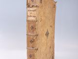 un vieux livre posé sur une table blanche, près d'un mur bleu