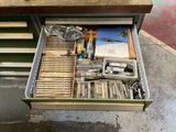 un tiroir rempli d'outils posé sur une table dans un garage