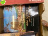 many books in a box that are sitting on the floor