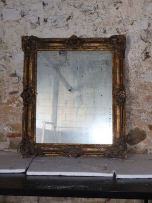 a mirror sitting on a table in front of a brick wall