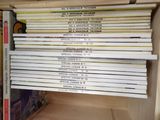 a lot of books that are stacked up on a shelf
