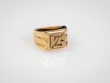 gros plan d'une bague en or sur une surface blanche